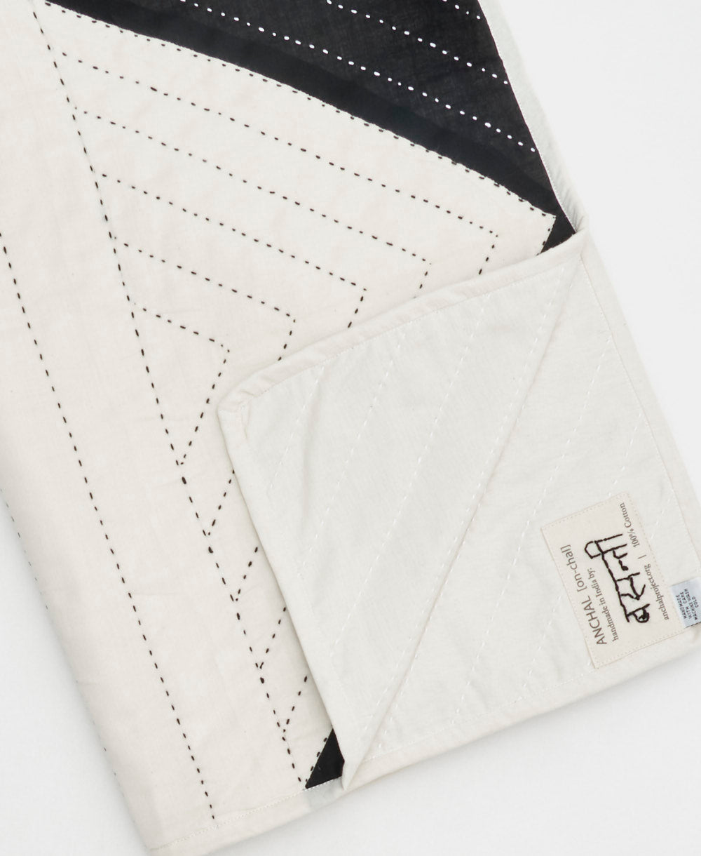 close-up of folded black and white triangle patchwork quilt handmade in India by Anchal artisans
