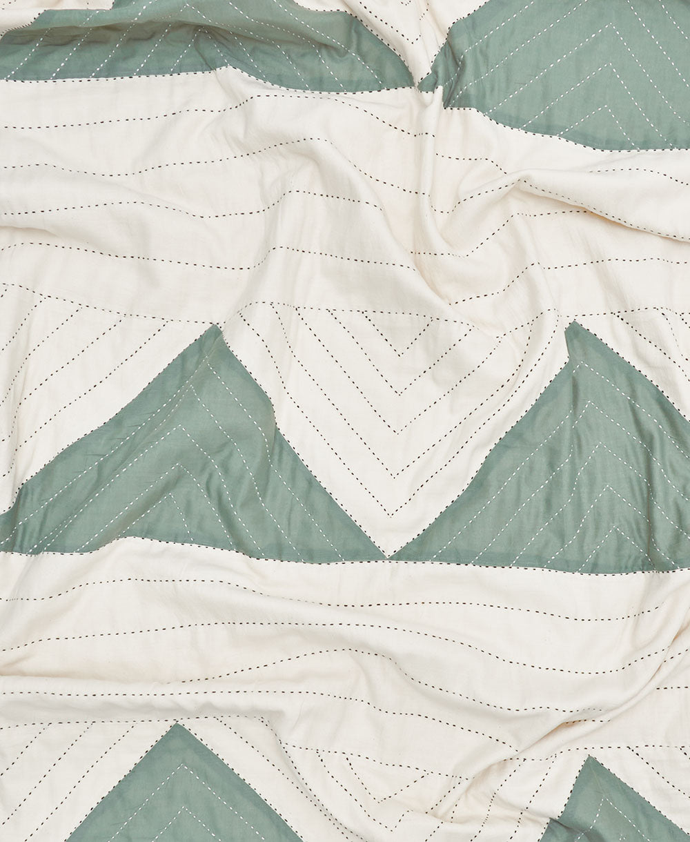 Close-up of a quilt with green and white chevron pattern