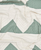 Close-up of a quilt with green and white chevron pattern