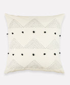 ivory throw pillow with black arrow stitching and black pom poms