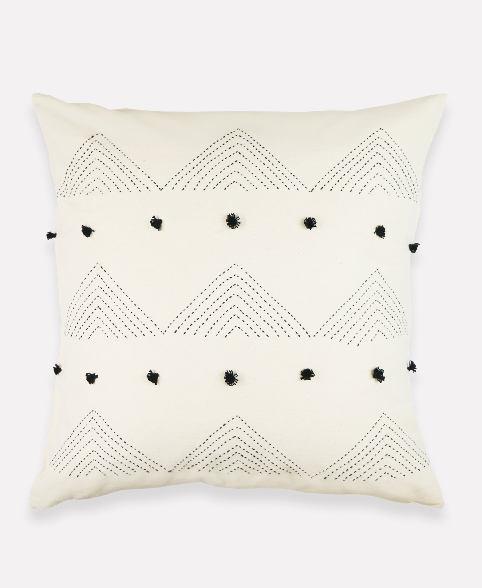 ivory throw pillow with black arrow stitching and black pom poms