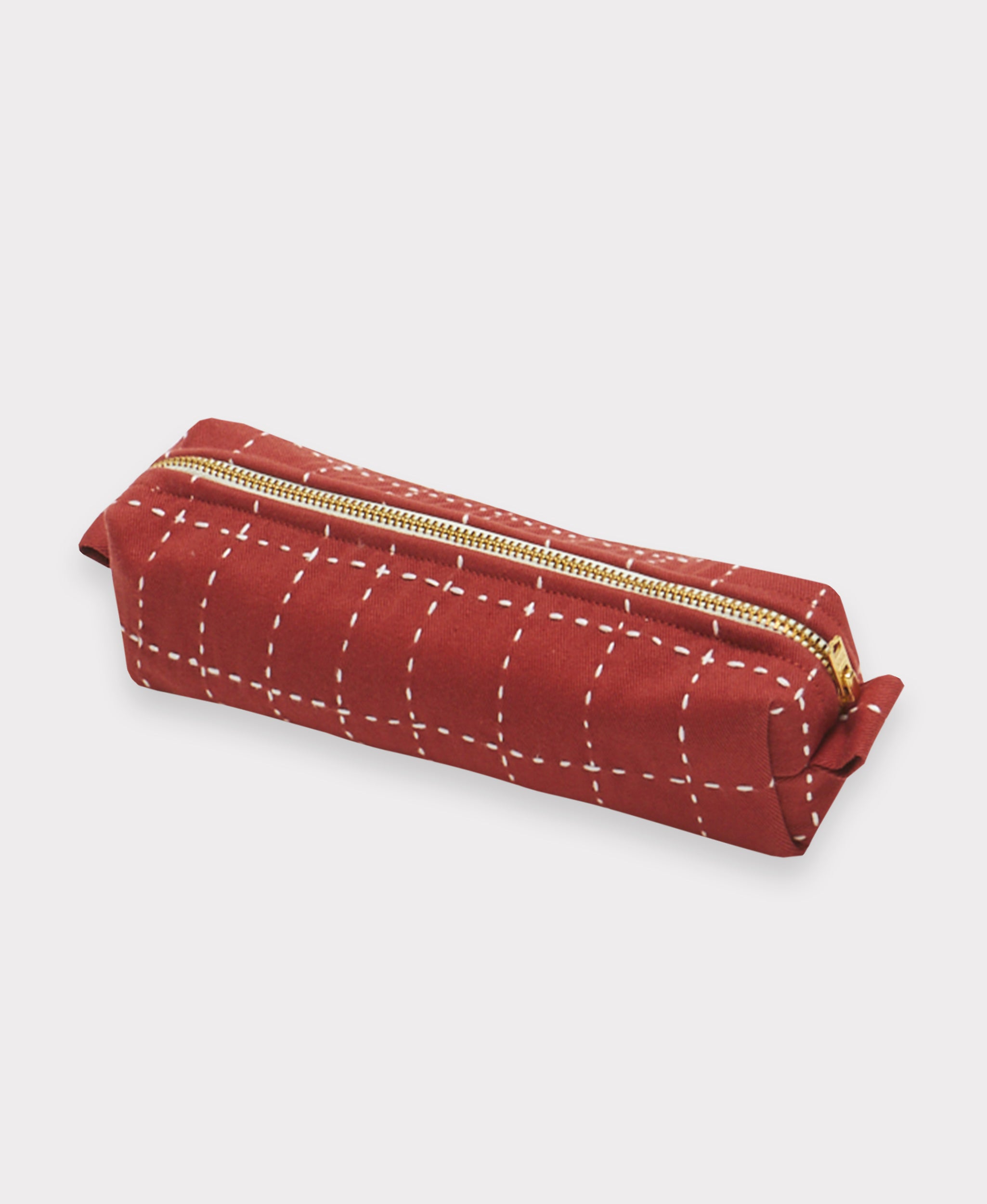 rust red small toiletry bag with white hand-stitched embroidery