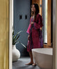woman wearing a pink paisley vintage silk robe
while getting ready in her bathroom 