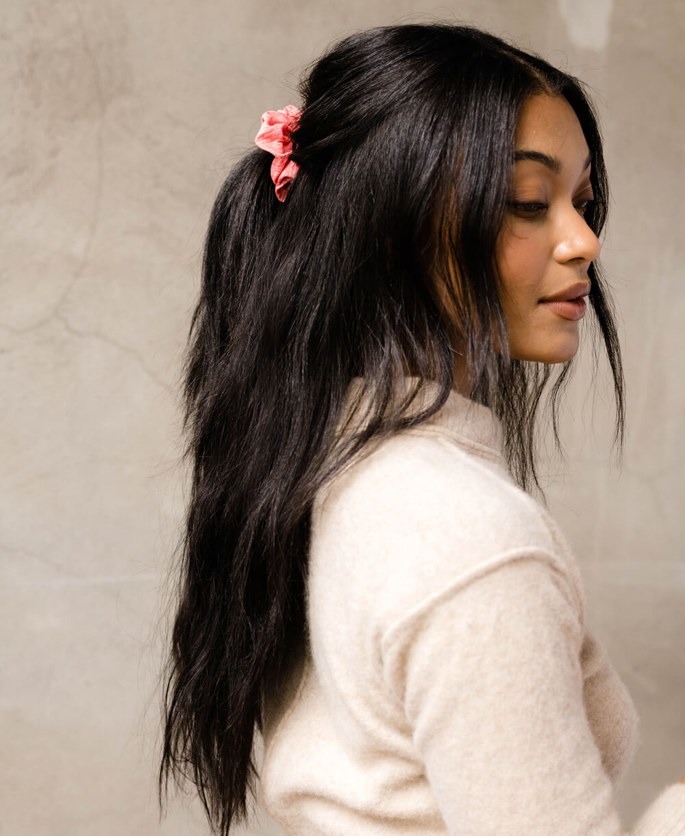 woman with long dark brown hair wearing a coral pink scrunchie in hair made from vintage cotton saris