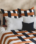 Decorative pillows with striped patterns on a bed