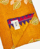 yellow kantha quilt throw featuring the hand stitched signature of the maker 
