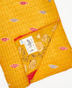 yellow kantha quilt throw featuring the hand stitched signature of the maker