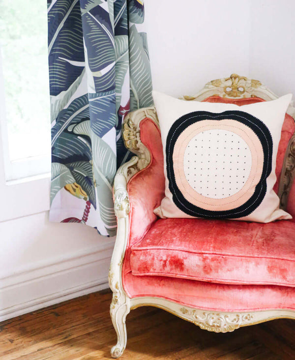 modern fair trade throw pillow in vintage pink velvet chair