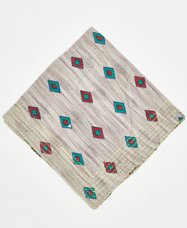 beige cotton bandana with teal and red diamonds and neon yellow kantha stitching along its edges