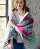 woman draped in a blue and yellow kantha quilt throw 
