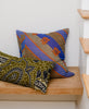 Colorful throw pillows stacked on a wooden bench 