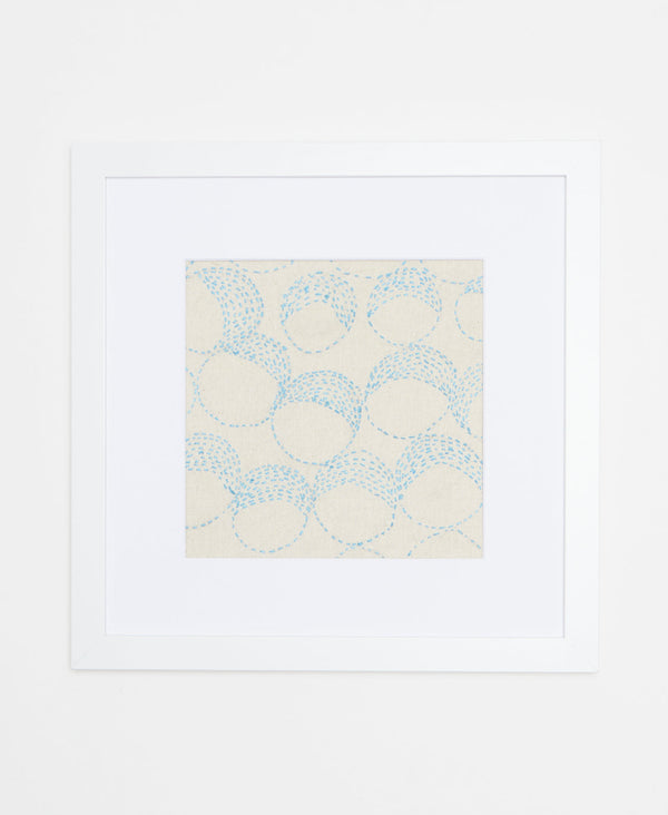 Handcrafted artisan-made framed artwork featuring light blue circular stitching on a white background  