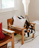modern leather chairs with cross-stitch minimalist pillow and plaid quilt throw