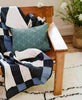 modern plaid quilt in vintage modern leather chair with spruce green throw pillow