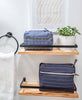Navy Pin-Stitch Toiletry Bag on shelf in bathroom with matching cross-stitch toiletry bag in slate