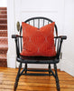 organic cotton rust throw pillow in vintage chair