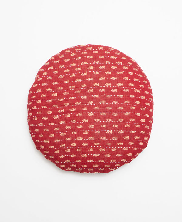 Red vintage kantha round throw pillow featuring a small beige leaf print through out 
