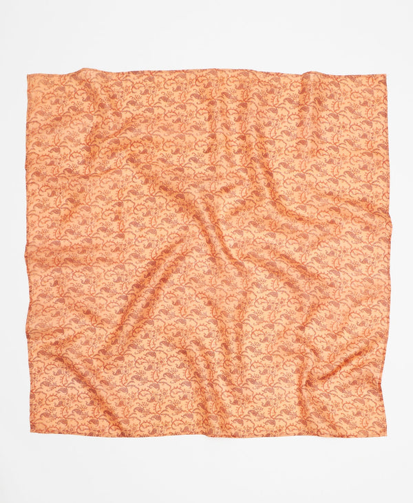 Artisan-made light orange silk square scarf with an intricate darker orange pattern
