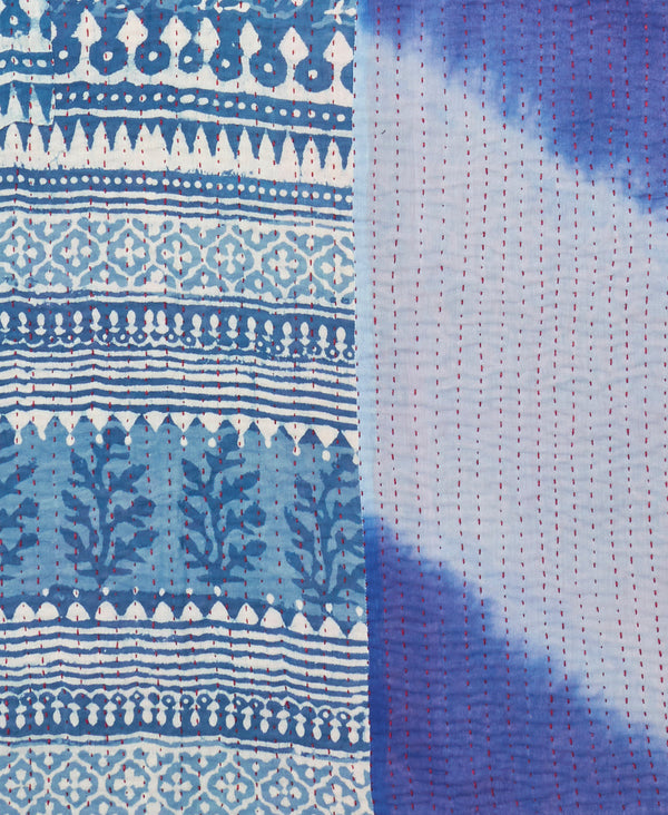 Contrasting blue patterns and red traditional kantha hand stitching make up this one of a kind throw quilt 