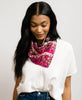 woman in white shirt and blue jeans wearing a bright pink floral vintage silk bandana from Anchal tied around her neck
