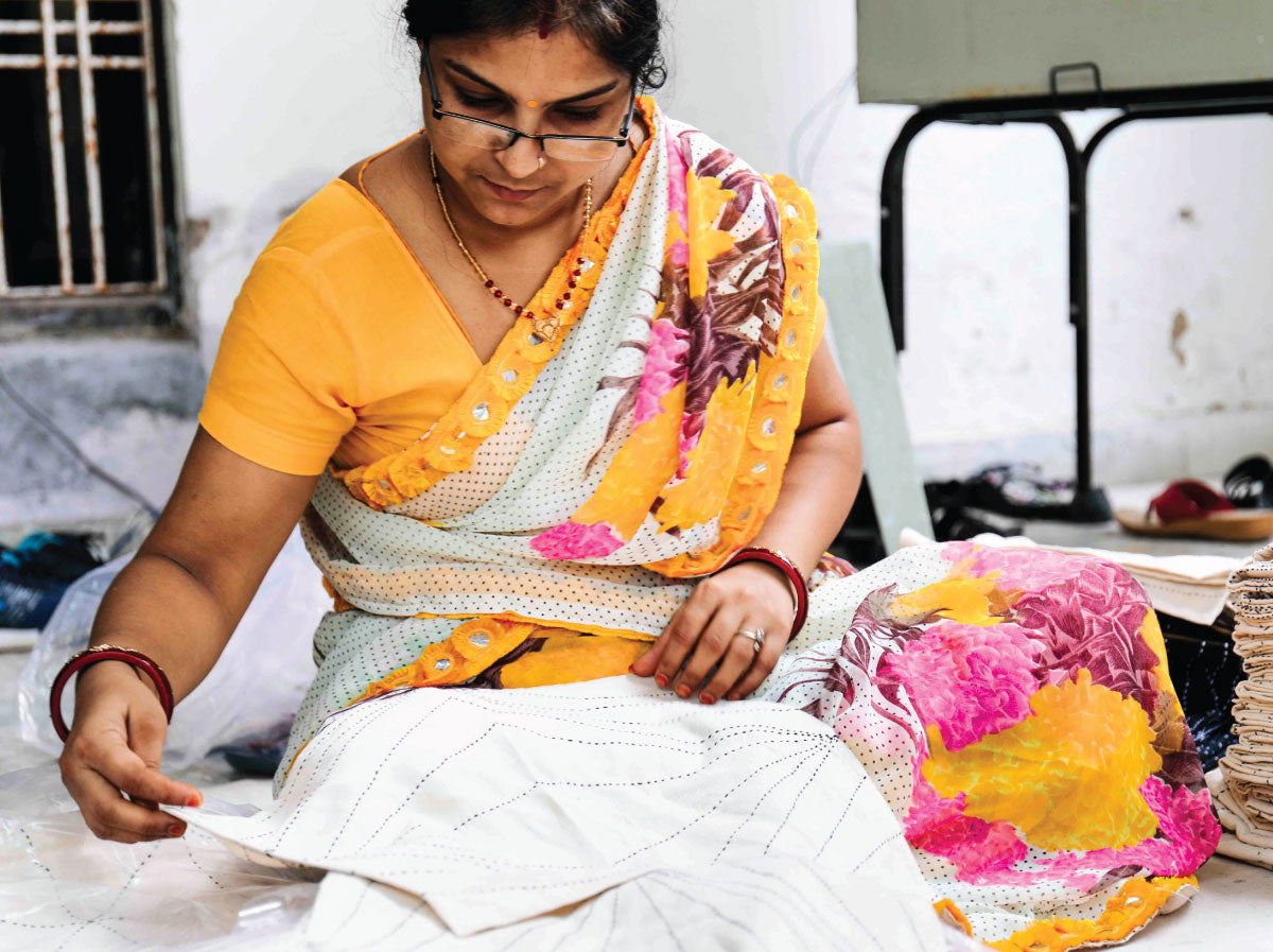 Anchal artisan hand sewing a pattern into a quilt