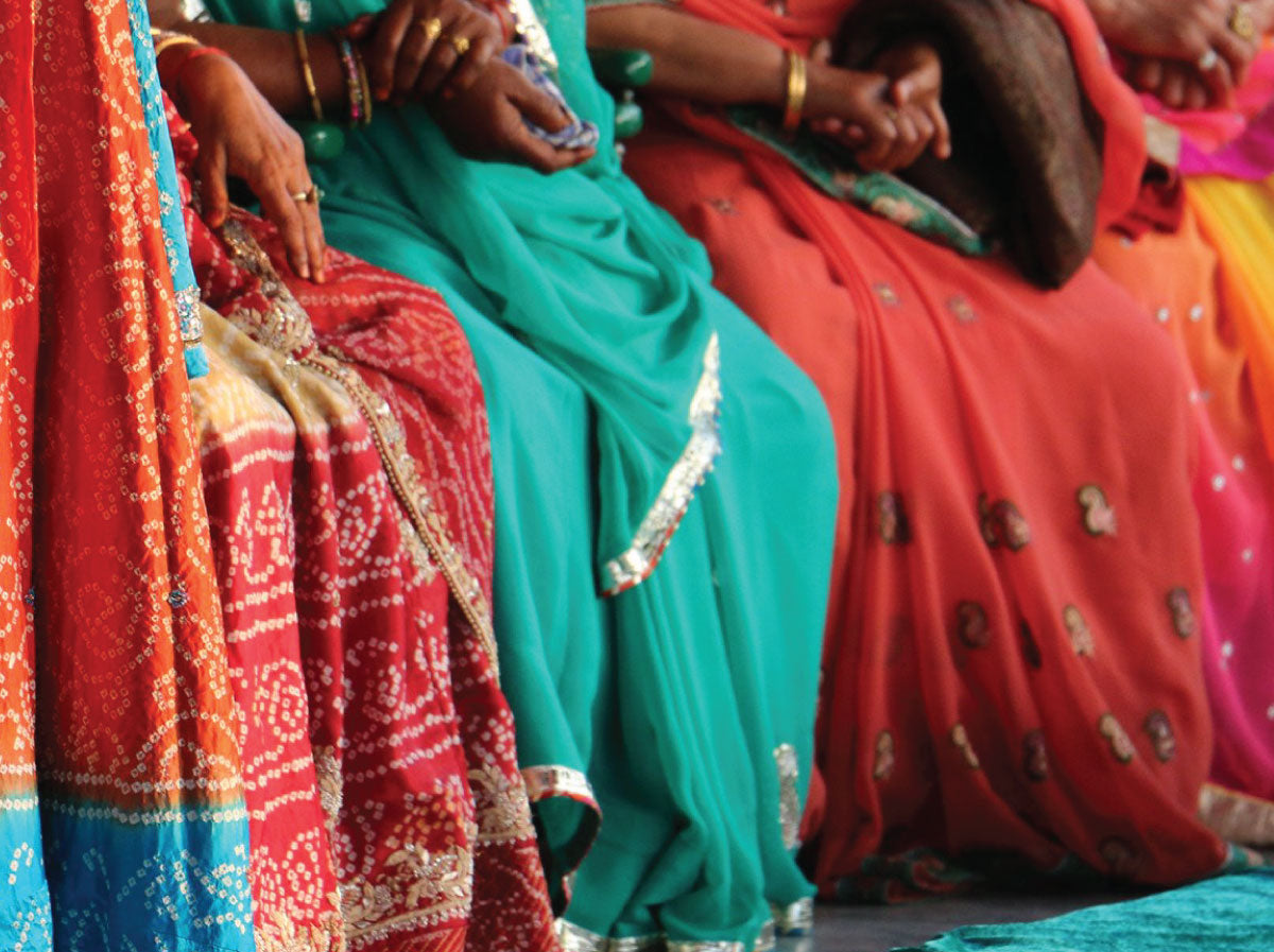 Close up photo of traditional saris in colors of red teal and orange