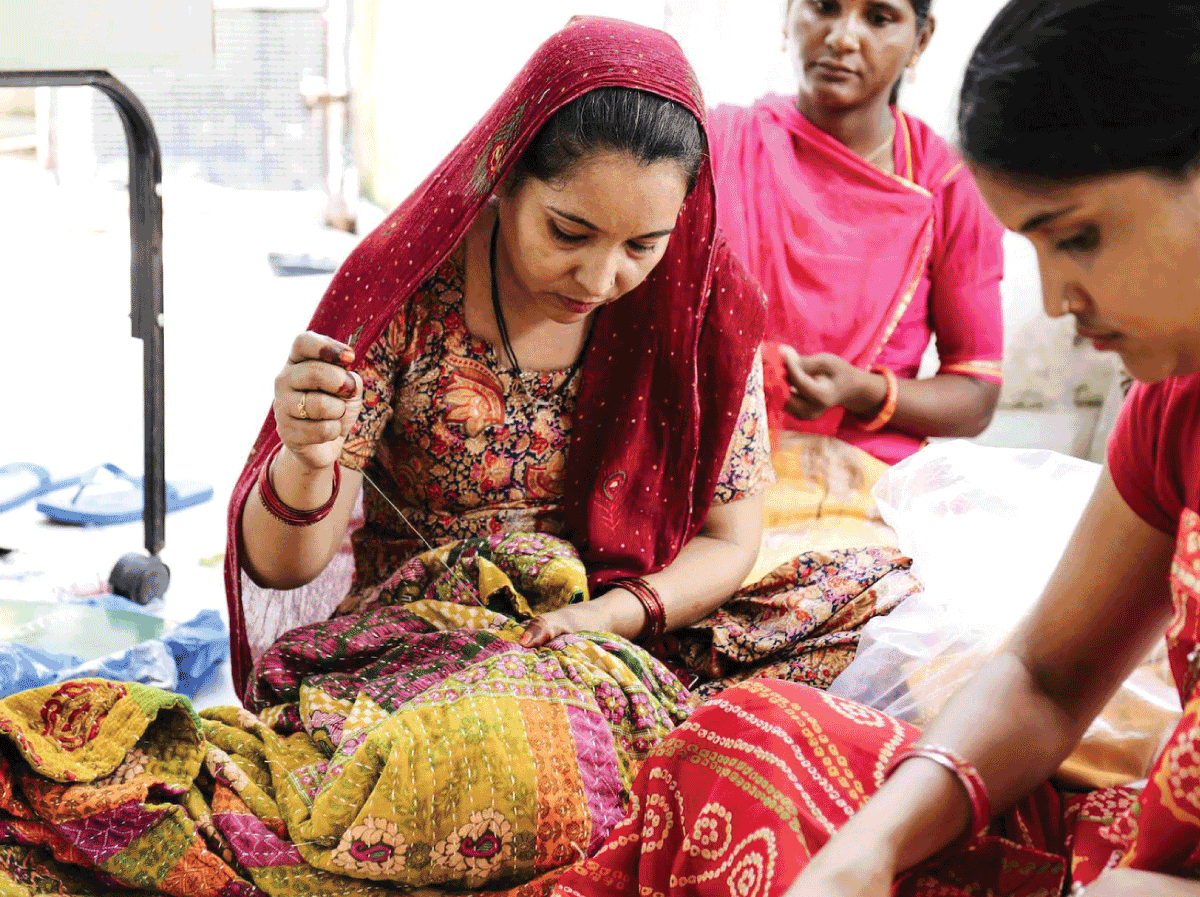 Artisan working on the hand stitching on a Kantha quilt