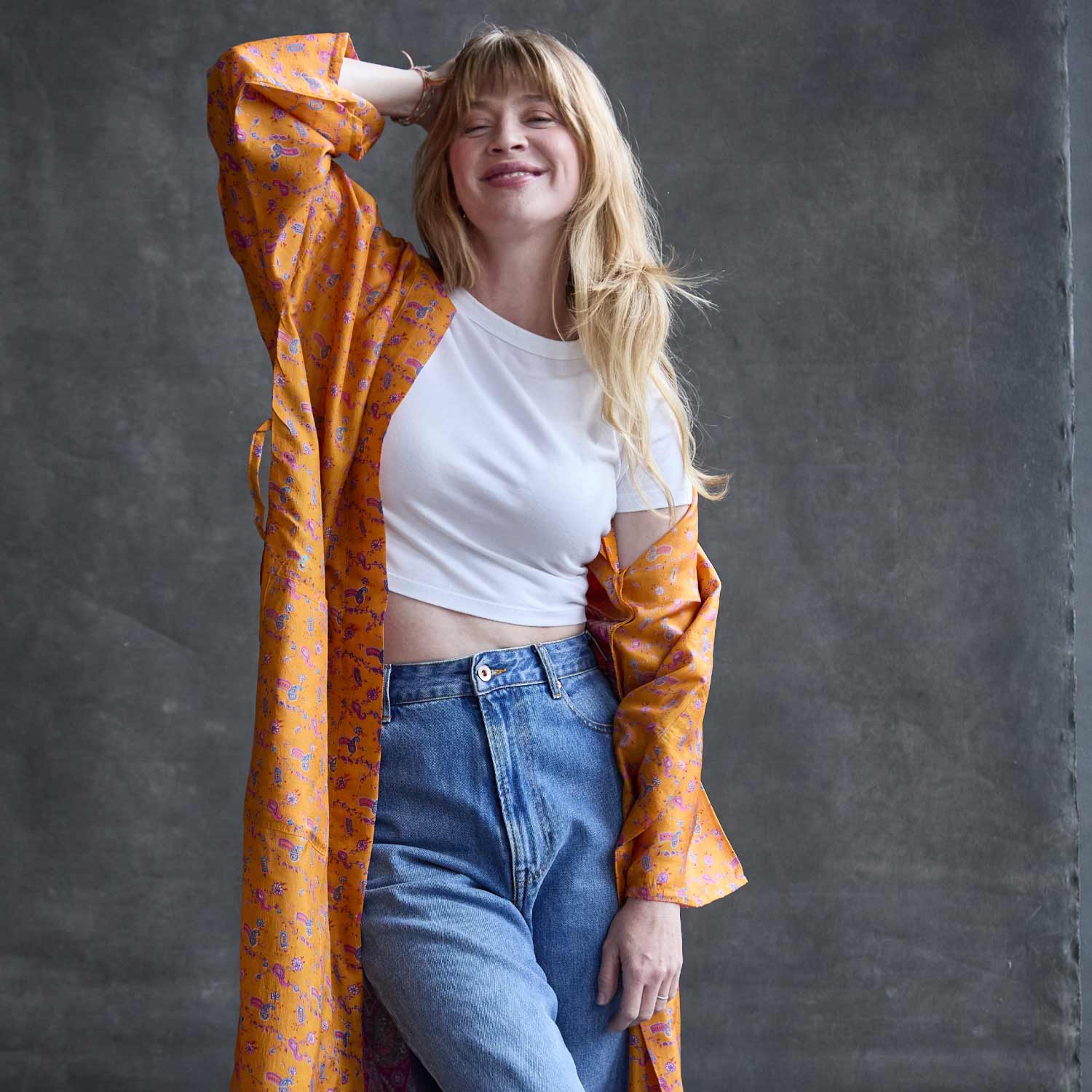 woman wearing vintage silk robe in orange as a duster with jeans and a white t-shirt