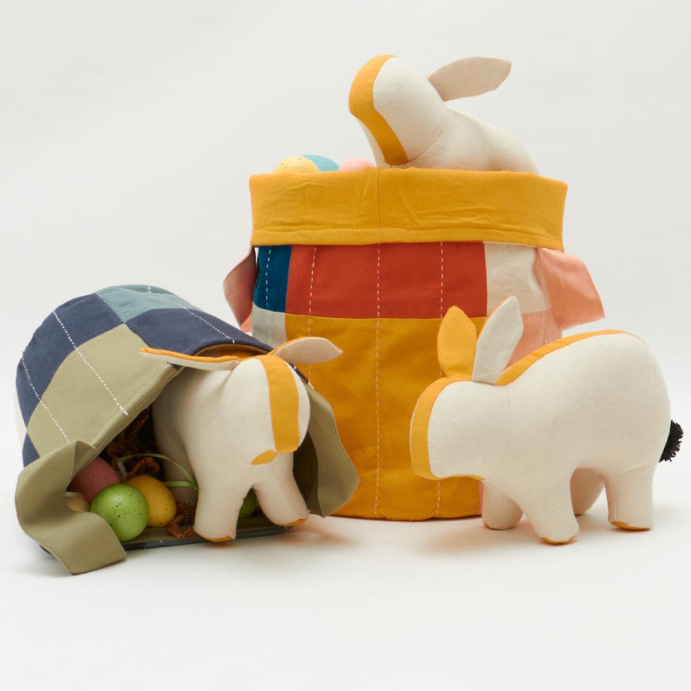 reusable easter baskets with grass filling, eggs, and stuffed animal rabbits
