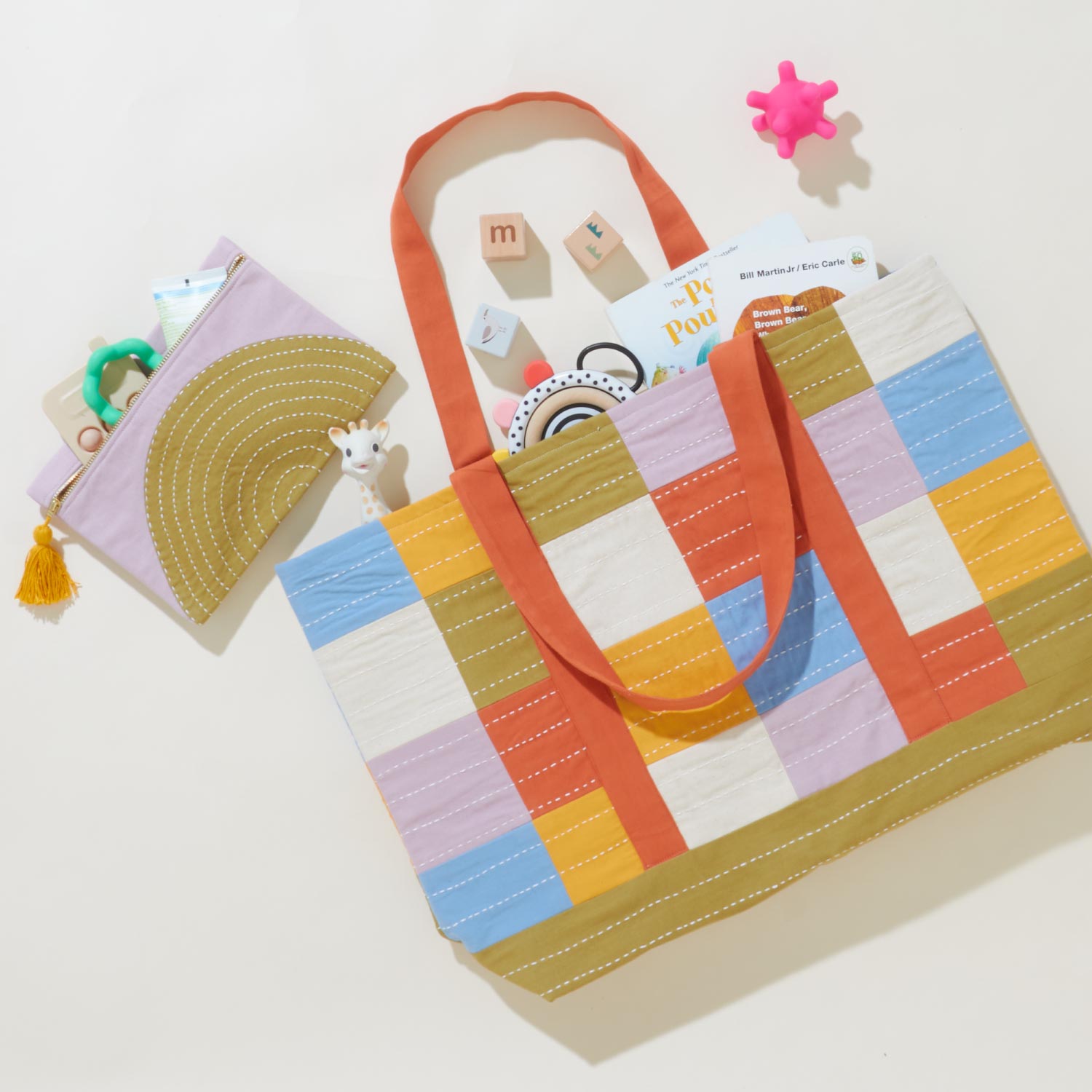 colorful tote bag in a checkered print with children's books spilling out