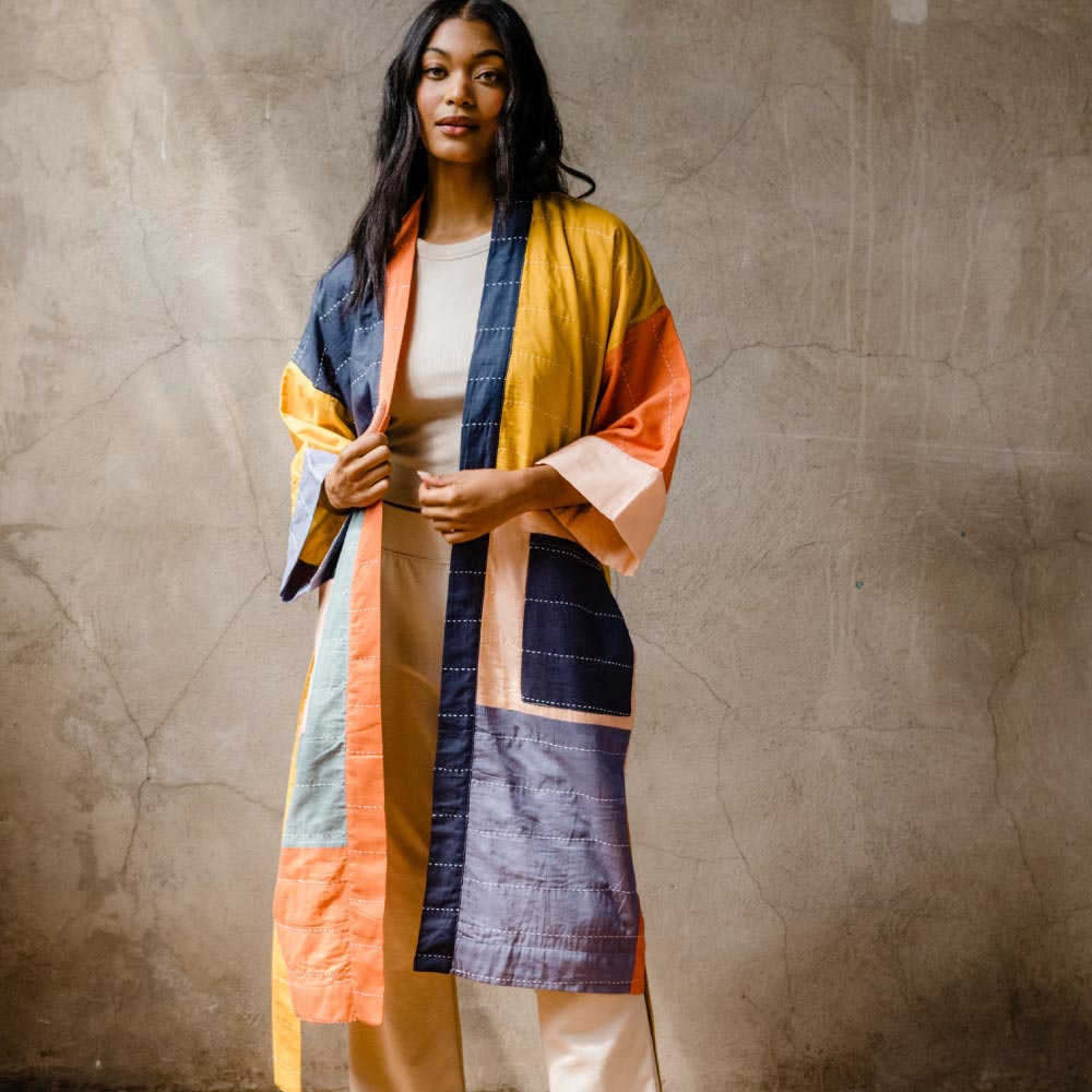 woman wearing colorblock robe in rainbow hues made from 100% organic cotton