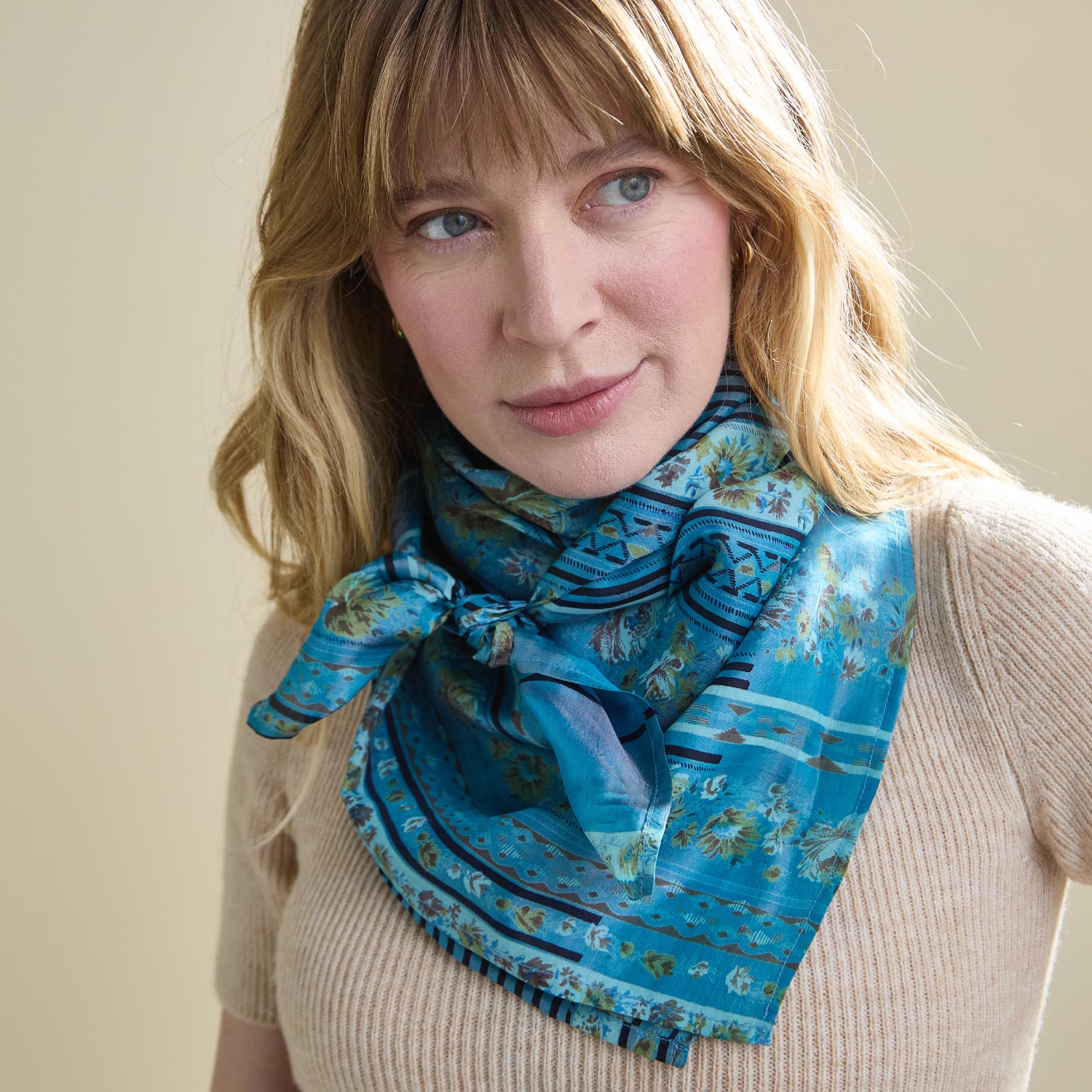 woman wearing blue silk square scarf tied around neck
