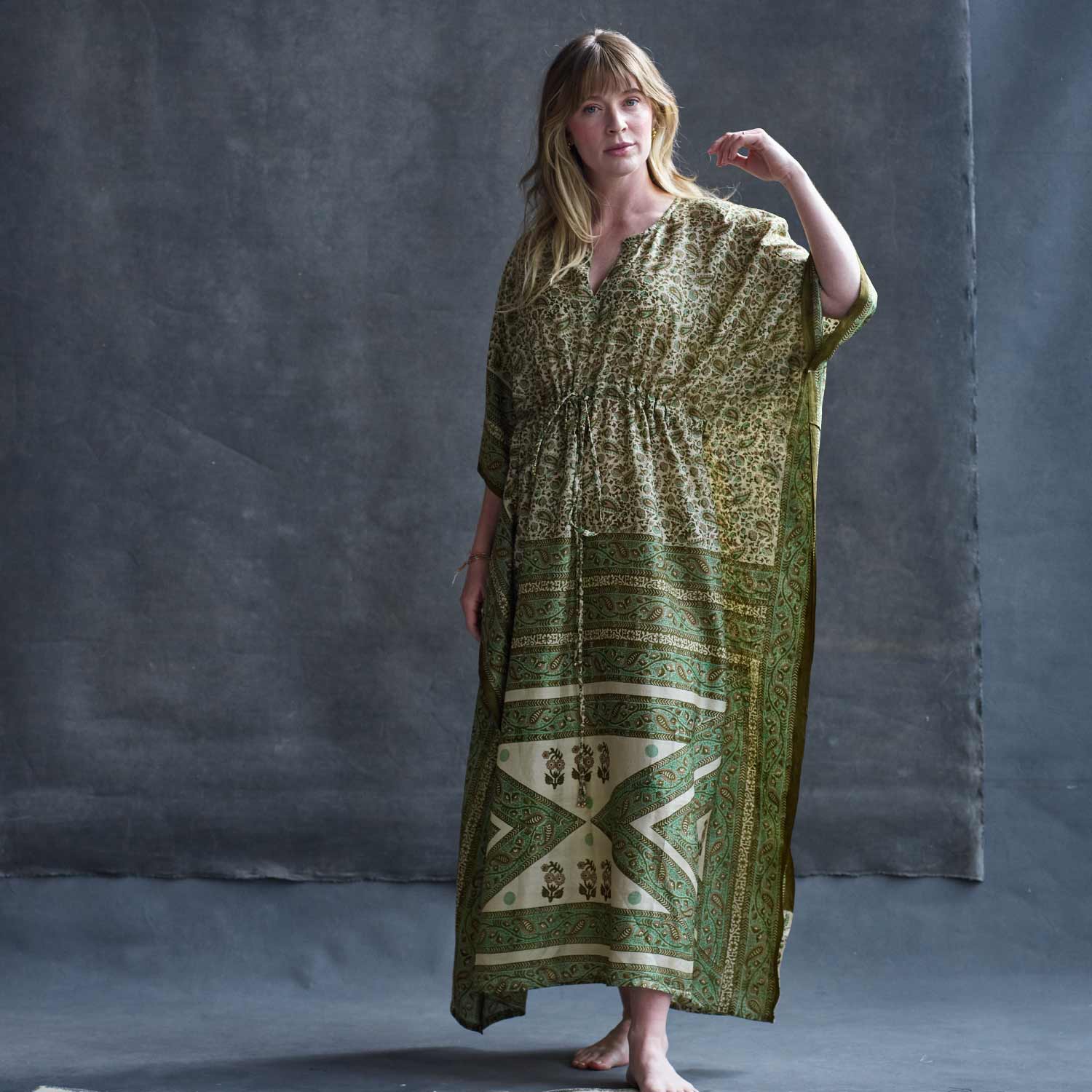 woman wearing green silk kaftan with empire waistline and short sleeves