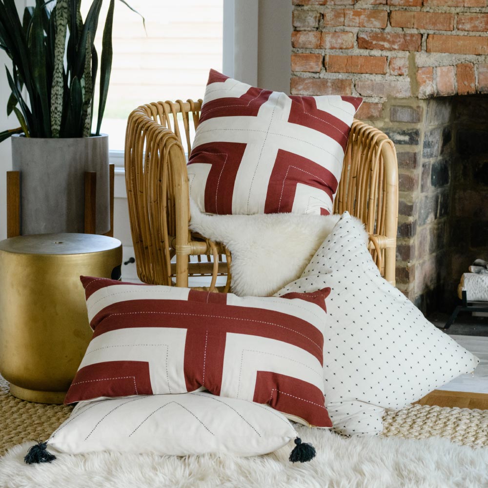 rust red and white geometric throw pillows in modern rattan chair with white fur rug