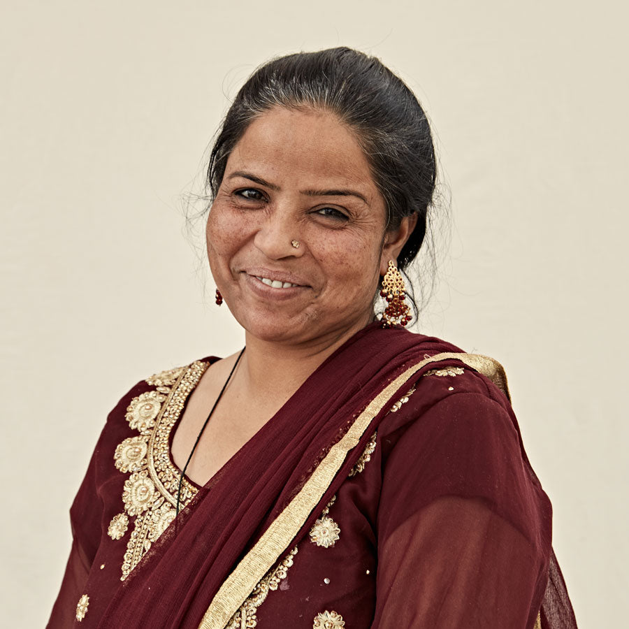 portrait of Project Assistant Shama wearing maroon and gold accented sari smiling