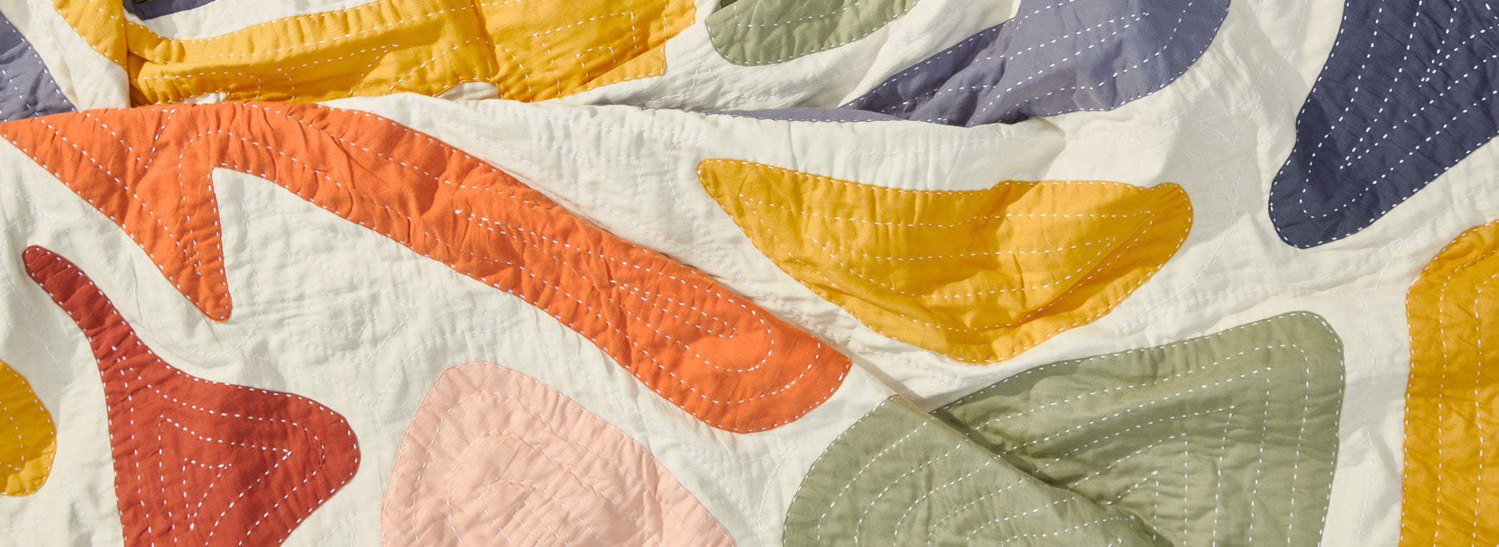 colorful hand-embroidered quilt made from organic cotton featuring rainbow organic shapes handmade in India