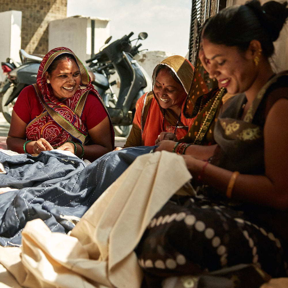 group of 3 women artisans in Ajmer, India in Anchal's studio hand-embroidering white & navy quilts