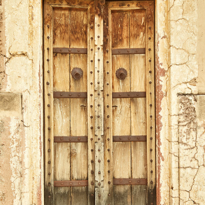 antique wooden door with rusted brass hardware on building in Ajmer, India