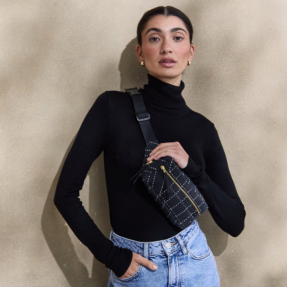 woman in black turtleneck wearing embroidered black belt bag made from 100% organic cotton