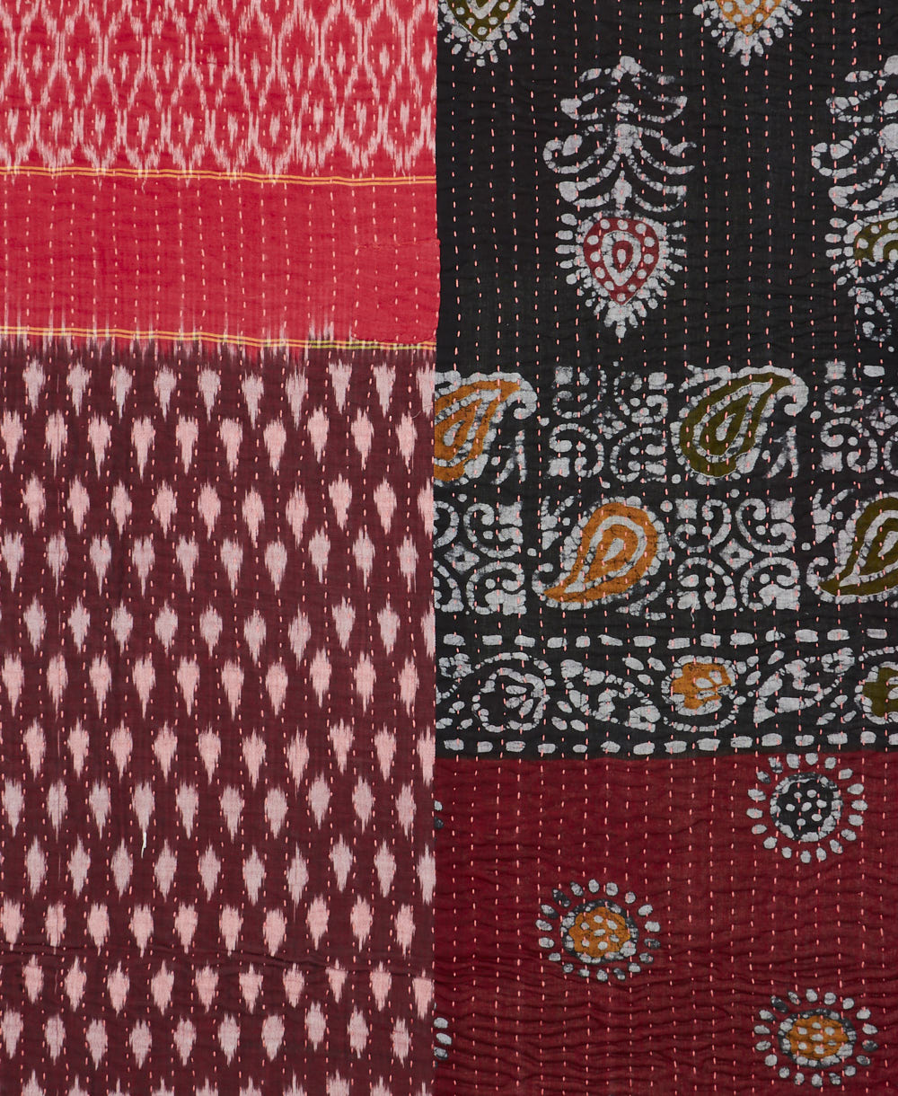 kantha quilt throw with a tag featuring the hand-stitched signature of the maker