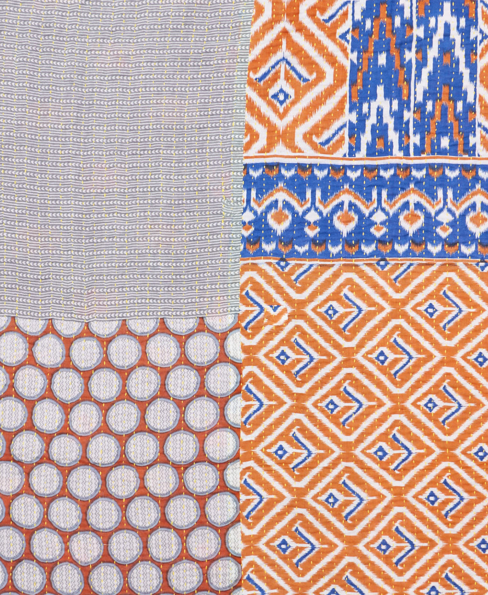 kantha quilt throw with a tag featuring the hand-stitched signature of the maker