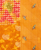 kantha quilt throw with a tag featuring the hand-stitched signature of the maker