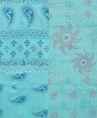 kantha quilt throw with a tag featuring the hand-stitched signature of the maker