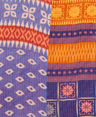 kantha quilt throw with a tag featuring the hand-stitched signature of the maker