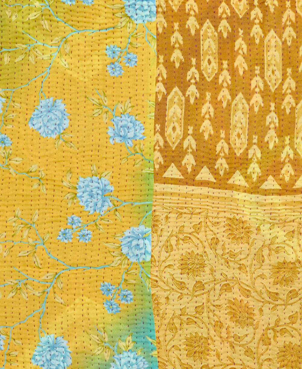 kantha quilt throw with a tag featuring the hand-stitched signature of the maker