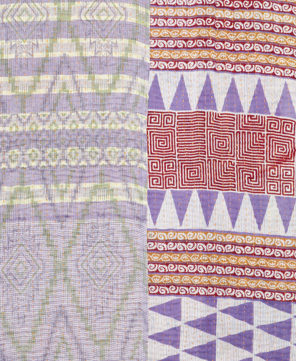 kantha quilt throw with a tag featuring the hand-stitched signature of the maker