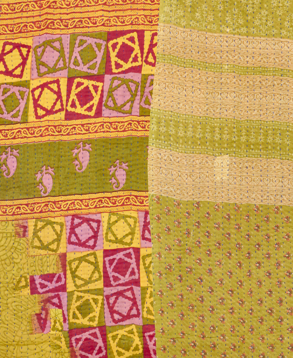 kantha quilt throw with a tag featuring the hand-stitched signature of the maker