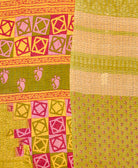 kantha quilt throw with a tag featuring the hand-stitched signature of the maker