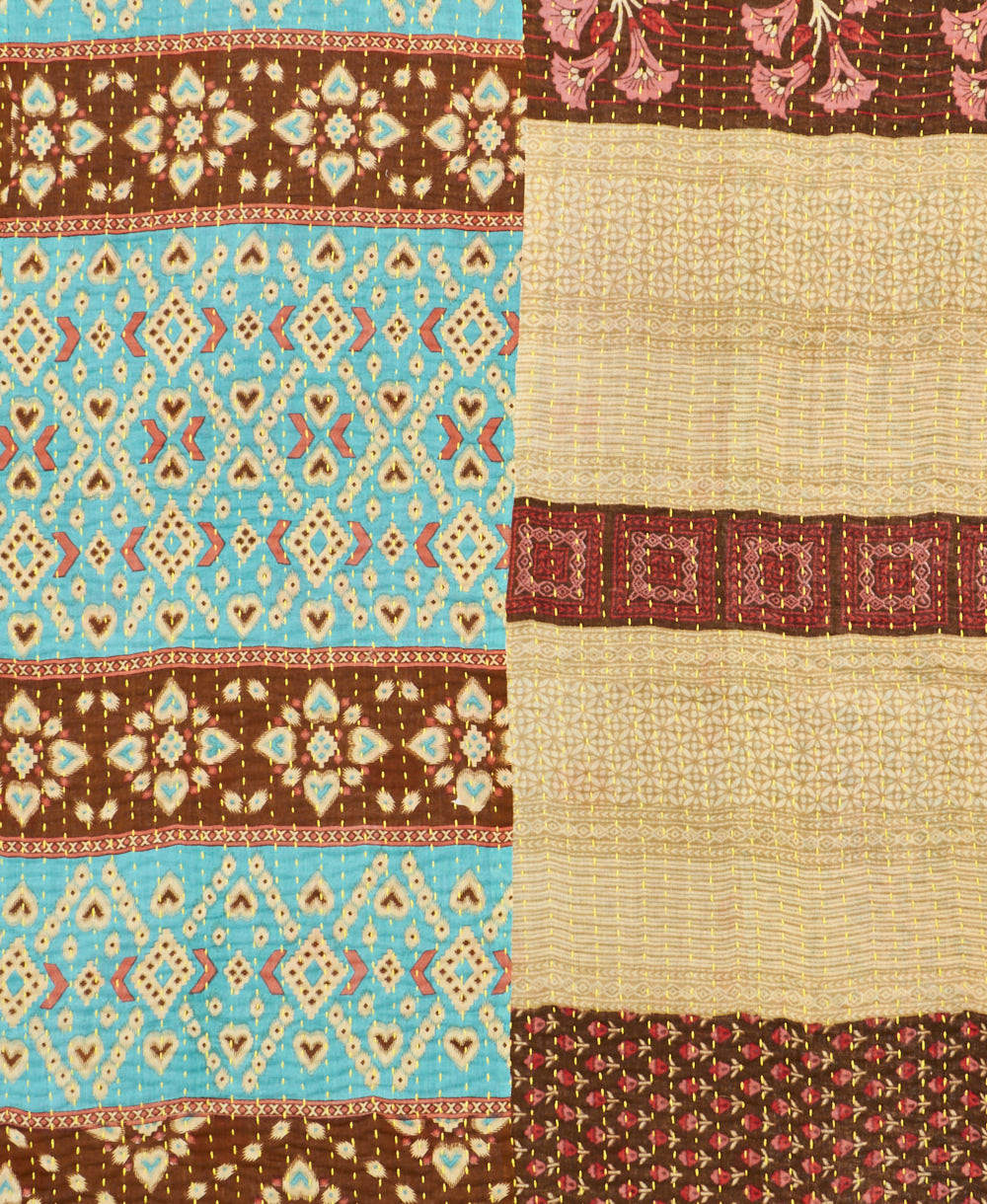 kantha quilt throw with a tag featuring the hand-stitched signature of the maker