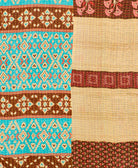 kantha quilt throw with a tag featuring the hand-stitched signature of the maker